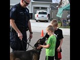 K9 Officer and his k9. Two young boys are petting the dog.