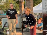A young child at a microphone on a stage